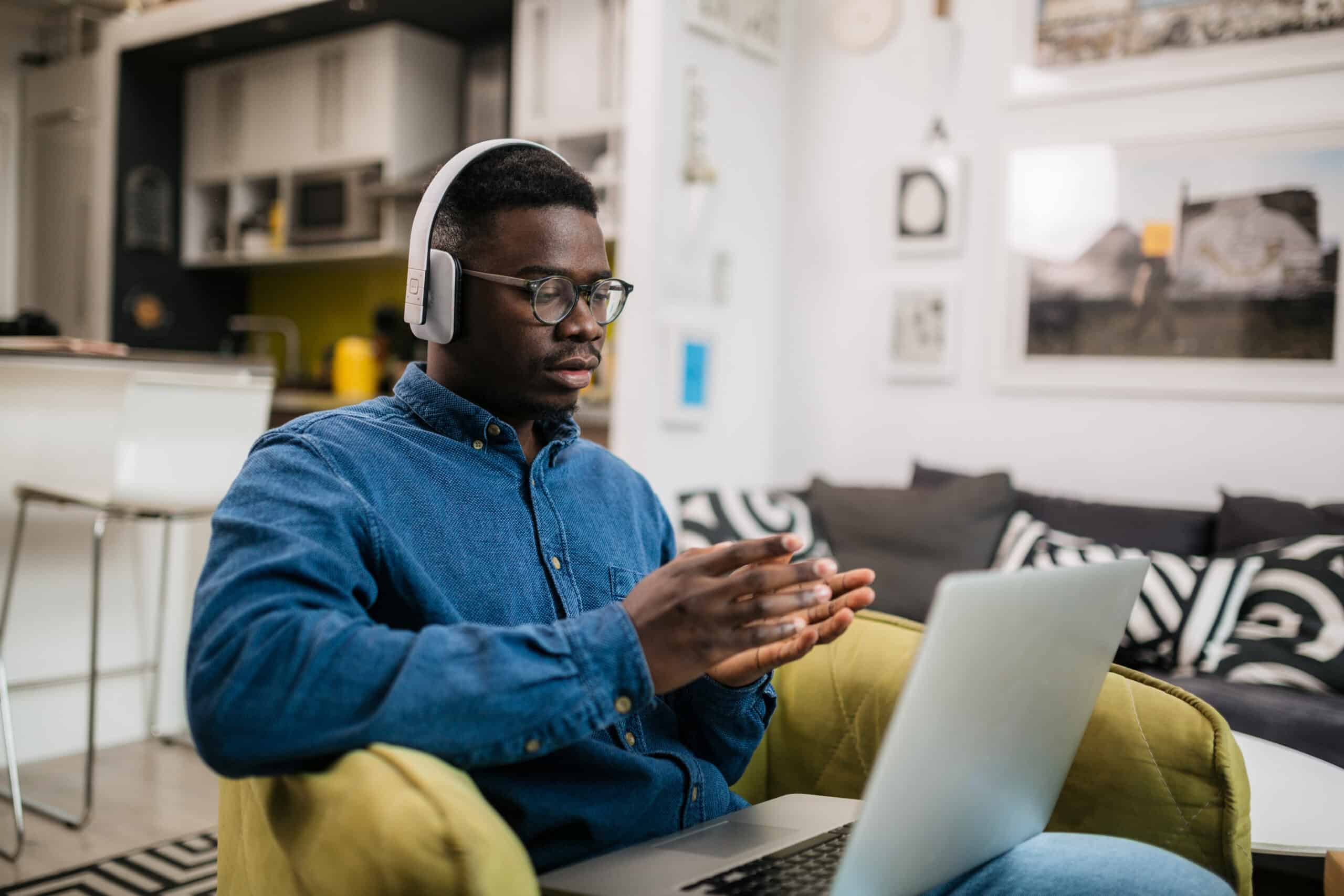 Young man on a laptop at home, wearing earphones
