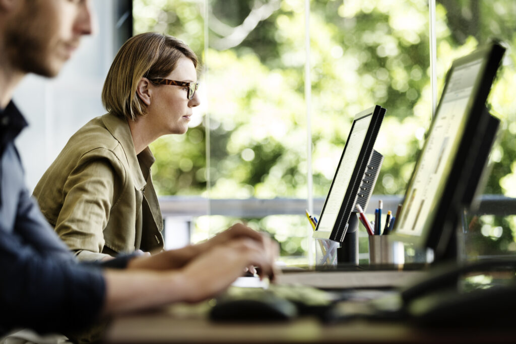 Colleagues at work at their desks, looking at computers