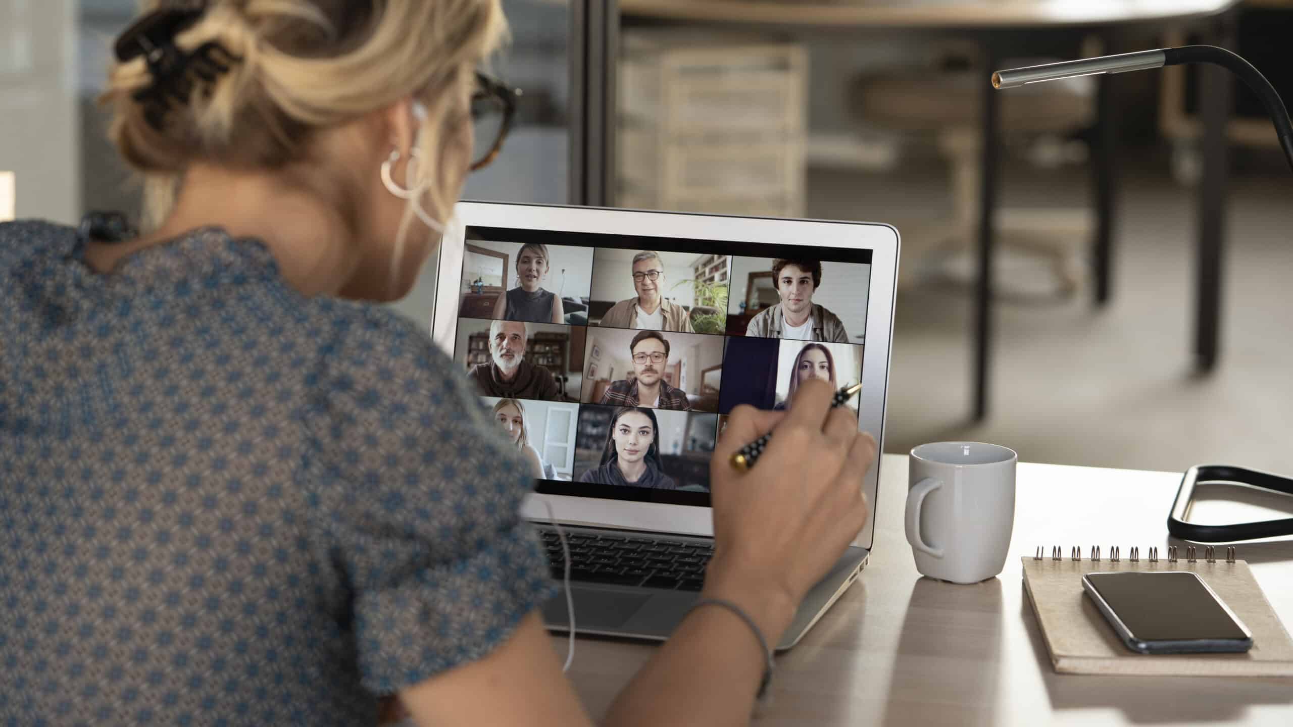 A woman on a video call with colleagues, watches her screen