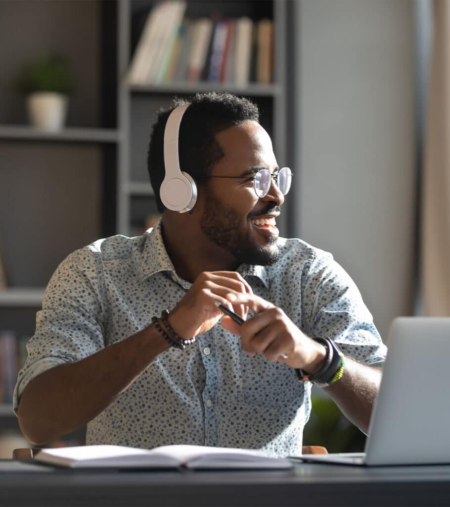 Man wears headphones in front of laptop
