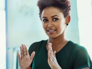 Close up of a woman at work, green shirt, making hand gestures