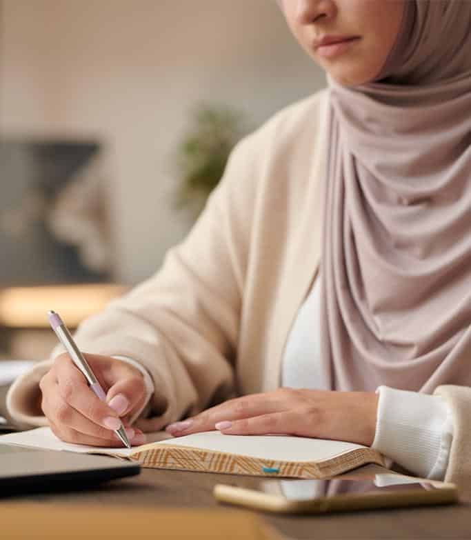 Close up of a woman writing in her notepad