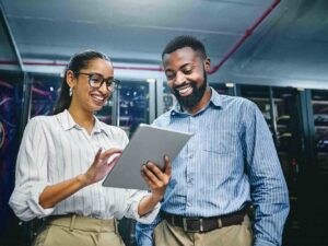 Smiling people interacting with tablet in data room